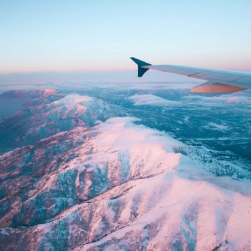 plane flying above white mountains during daytime