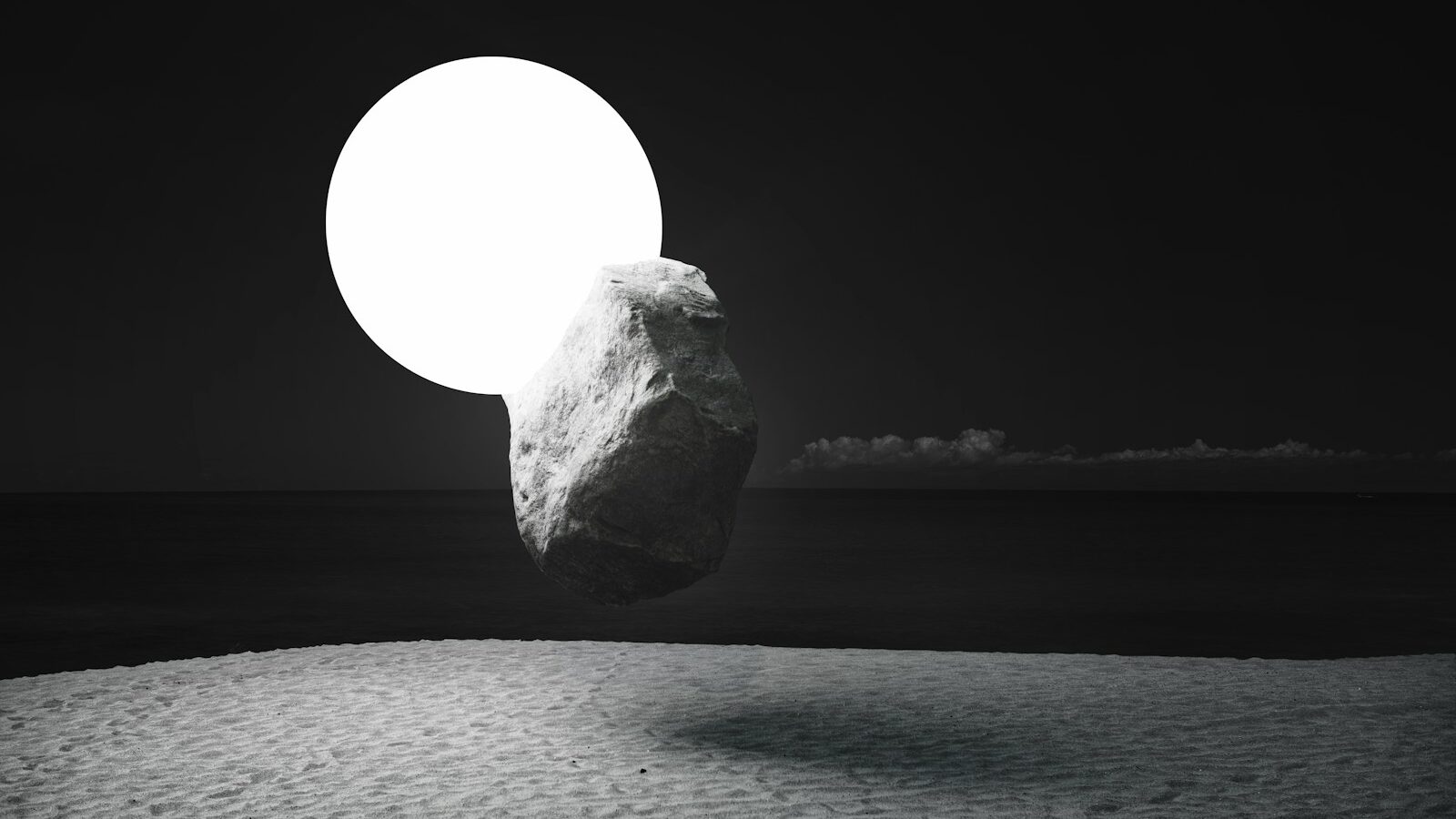 a large rock sitting on top of a sandy beach